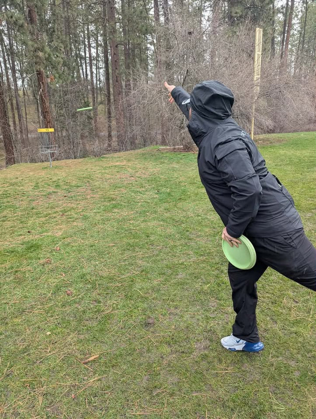 Tyler throwing a disc towards a basket.